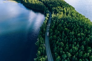 aerial-view-of-road-in-green-woods-and-blue-lakes-2023-11-27-05-04-18-utc